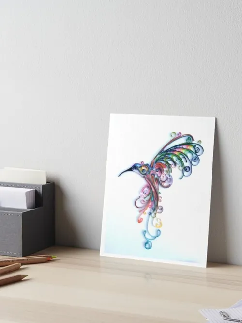 Ilustración de un colibrí colorido de Glimpsecraft expuesta sobre un escritorio.