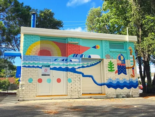 Colorful mural with waves and rainbow shapes on a building by Go Suga