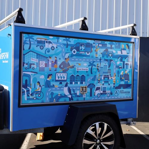 Blue utility trailer featuring an illustrated infographic on the side panel.