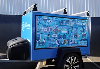 Blue utility trailer featuring an illustrated infographic on the side panel.