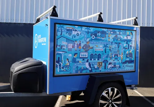 Blue utility trailer featuring an illustrated infographic on the side panel.