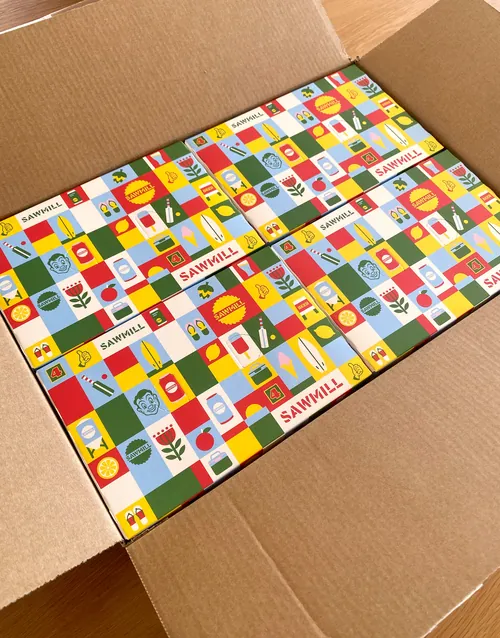 Colorful patterned cardboard boxes packed in a shipping box by Greg Straight