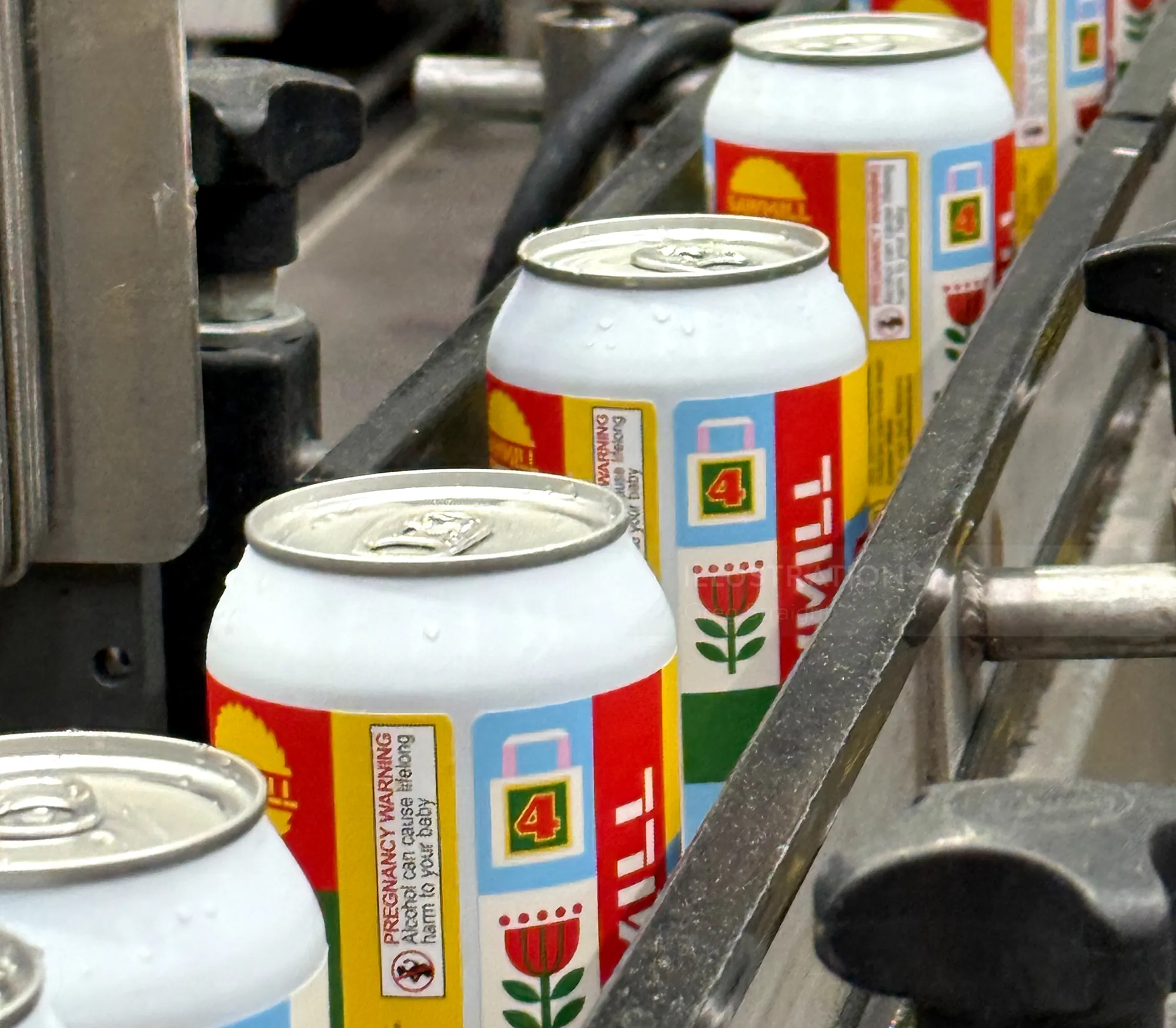 Soda cans with floral design on a production line by Greg Straight