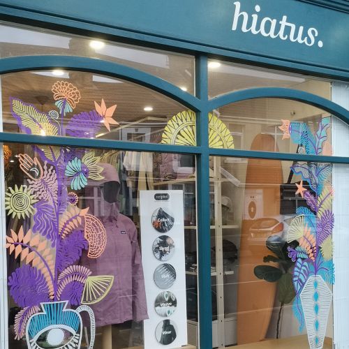 Window with colorful floral art by Hannah Davies at hiatus shop