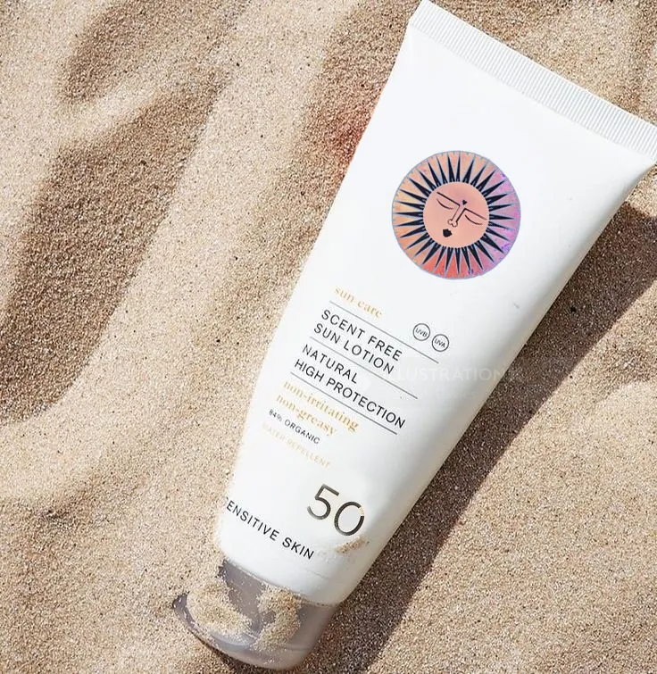 Sunscreen tube labeled SPF 50 on sand by Hannah Davies