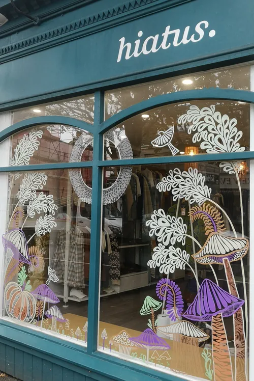 Window with whimsical mushroom and foliage art at Hiatus by Hannah Davies