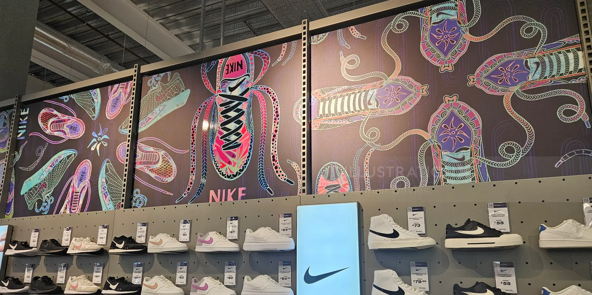 Mural colorido de Nike con diseños artísticos de zapatillas en la tienda.