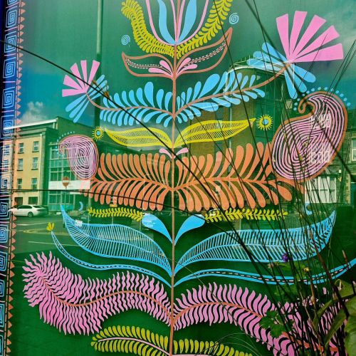 Colorful floral and bird window art with geometric patterns