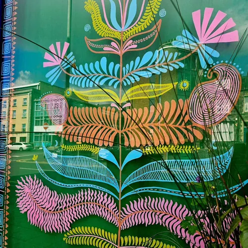 Colorful floral and bird window art with geometric patterns