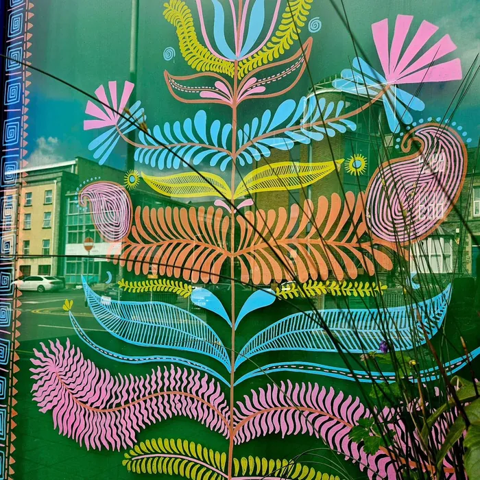 Colorful floral and bird window art with geometric patterns