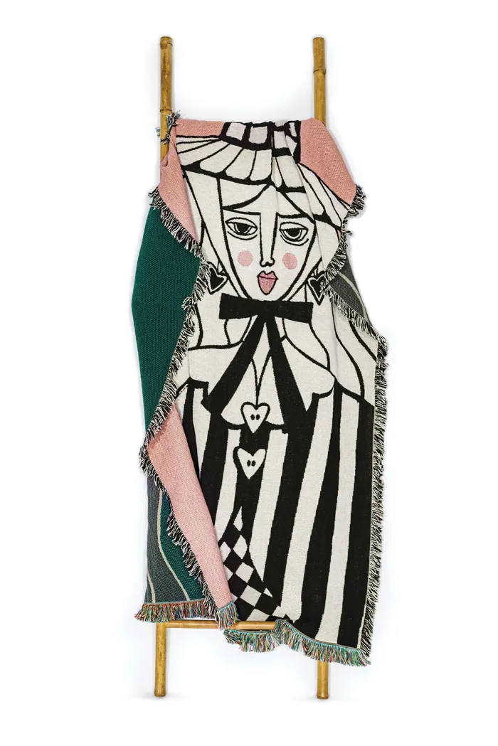 Woven tapestry with stylized female face and geometric black and white patterns
