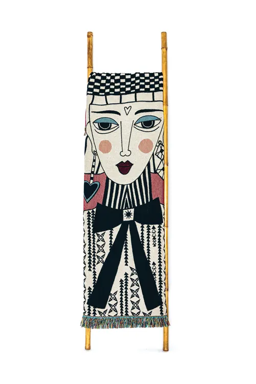 Textile wall hanging with stylized human face and geometric designs