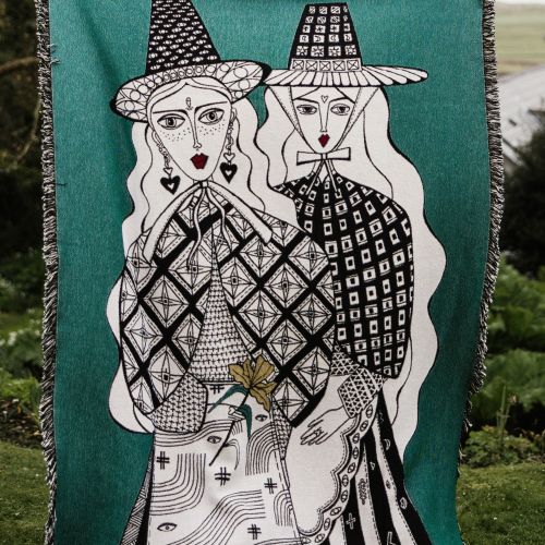 Woven textile artwork showing two stylized figures wearing hats by Hannah Davies