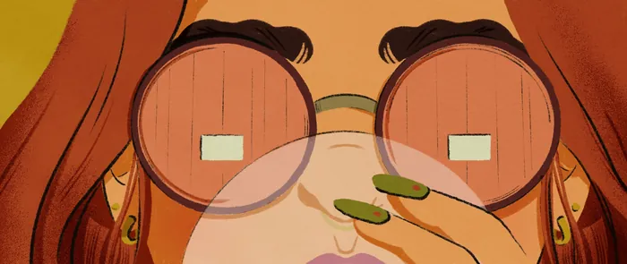 Close-up of person with round glasses holding green object near face.