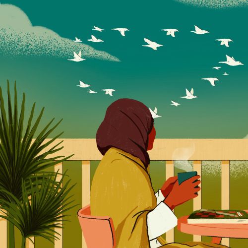 Person in headscarf sitting outdoors with cat and birds flying above.