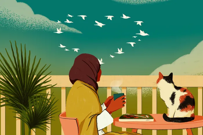 Person in headscarf sitting outdoors with cat and birds flying above.