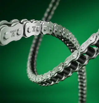 Close-up of a silver Renold Syno roller chain on green background
