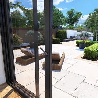 View through bi-fold door to sunny outdoor patio with furniture and plants