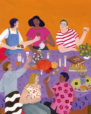 Group of six people sharing food around a table with candles and decorations