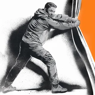Man exerting force while pushing a large orange curved structure