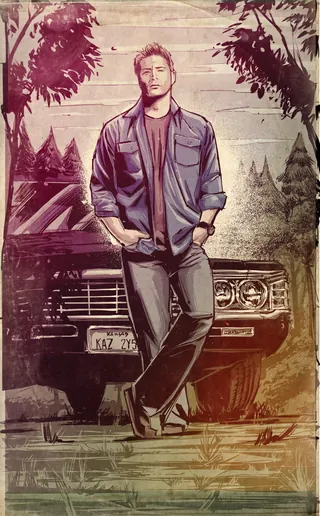 Man leaning on vintage car with trees in background