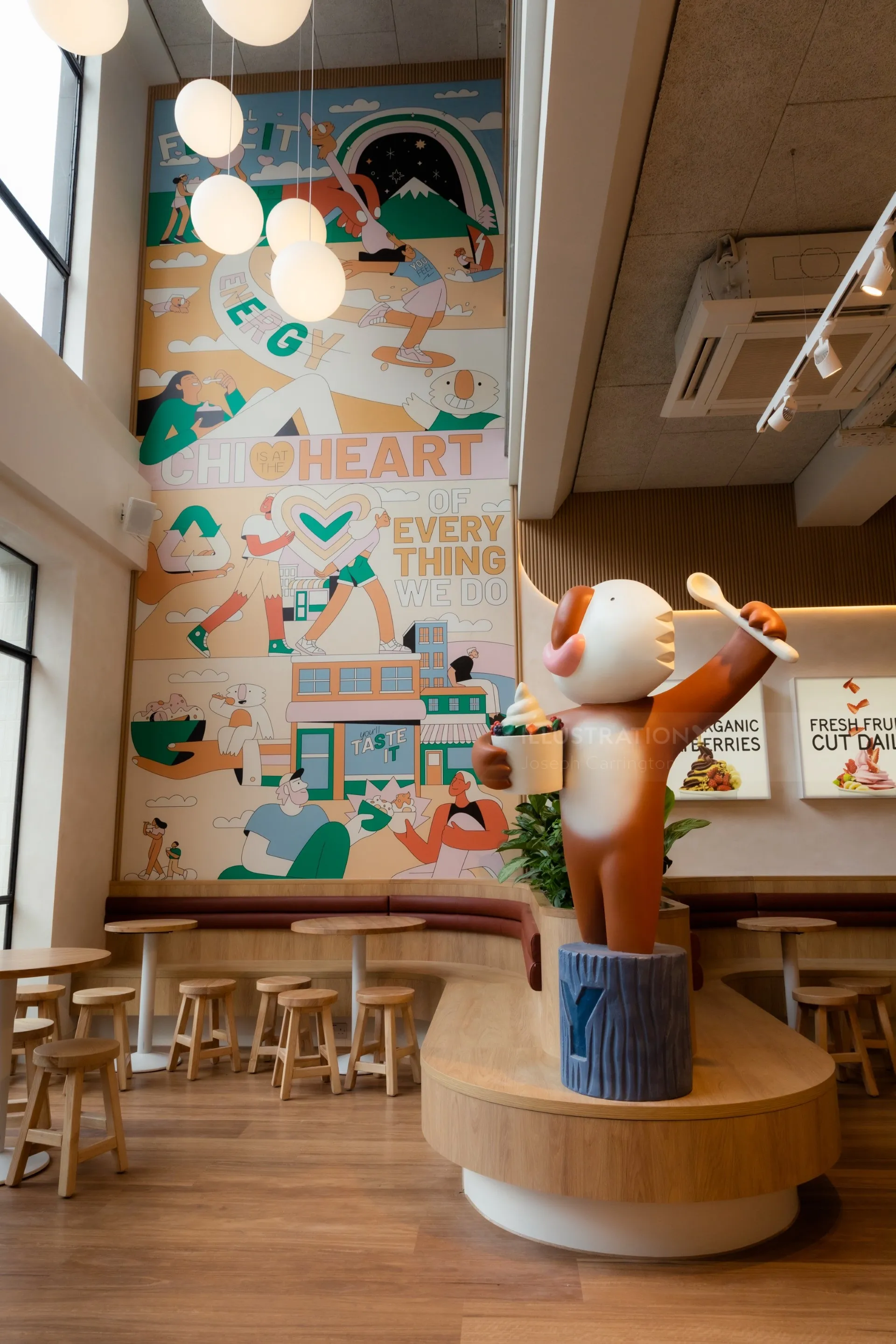 Joseph Carrington Wandgemälde mit einer skurrilen Katzenskulptur in einem modernen Café