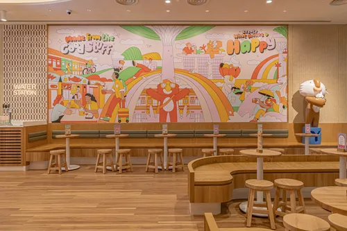 Colorful café mural with rainbows and playful figures by Joseph Carrington