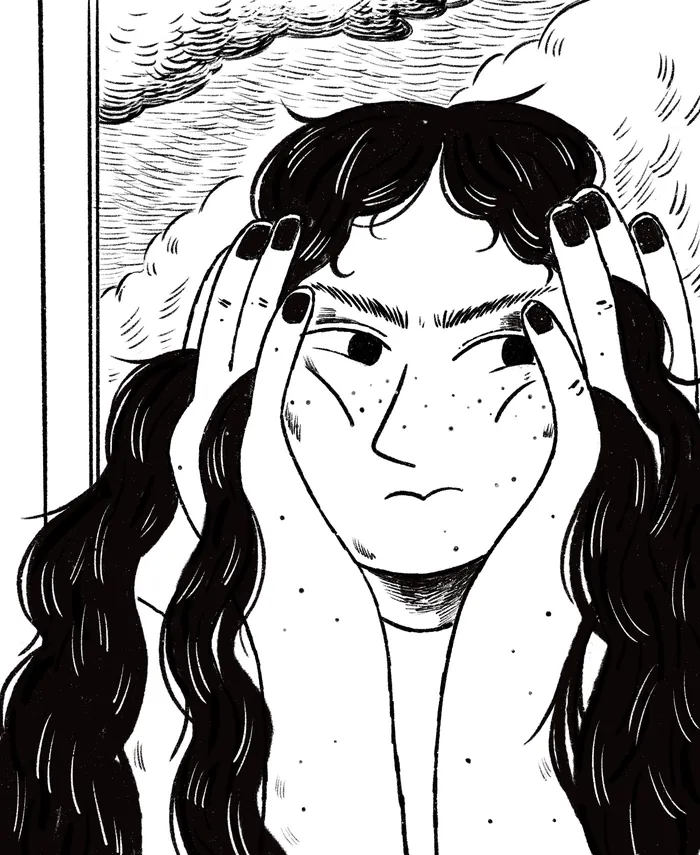 Person with long hair holding hands to face, looking thoughtful