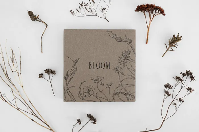 Book cover with BLOOM title and floral sketches surrounded by dried flowers