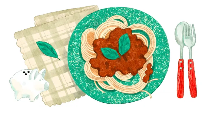 Plate of spaghetti with meat sauce and basil leaves next to fork and spoon.