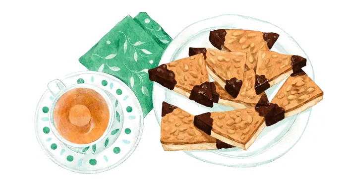 Plate of chocolate-dipped shortbread cookies and coffee cup