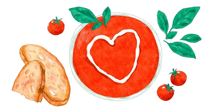 Bowl of tomato soup with cream heart, bread, and fresh tomatoes
