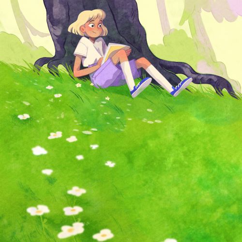 Young girl reading book under tree on green grassy field with white flowers