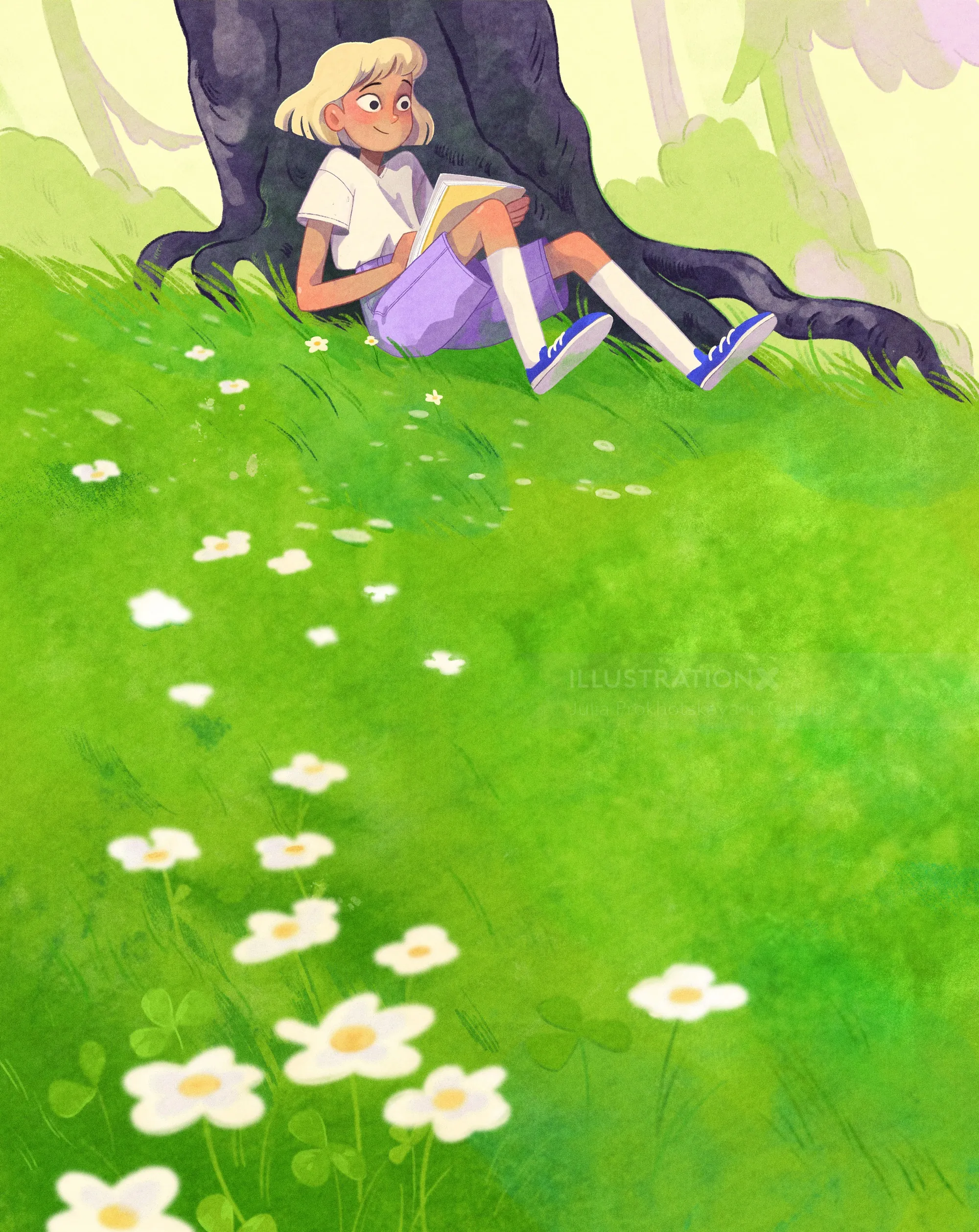 Young girl reading book under tree on green grassy field with white flowers