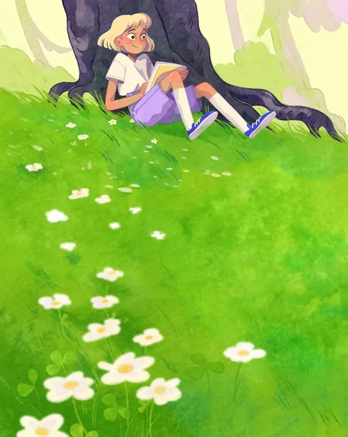 Young girl reading book under tree on green grassy field with white flowers