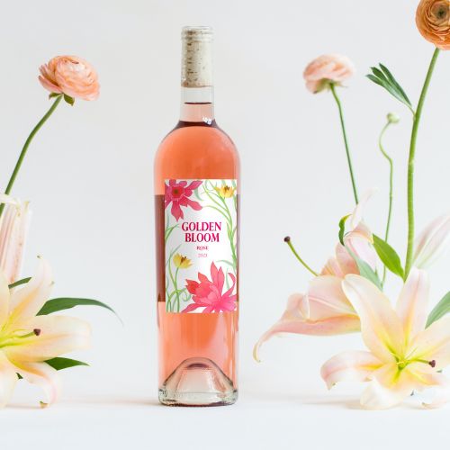 Golden Bloom rosé wine bottle surrounded by pink and white flowers