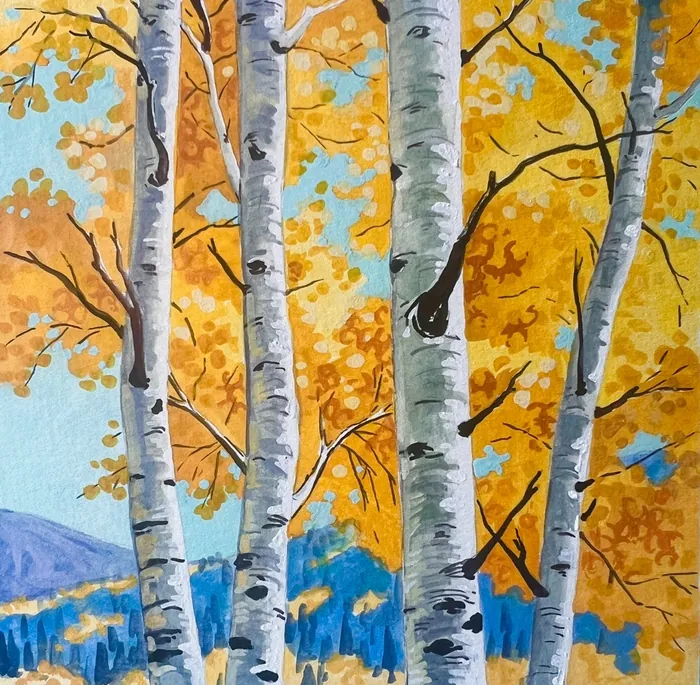 Birch trees with yellow leaves in autumn and distant blue mountains