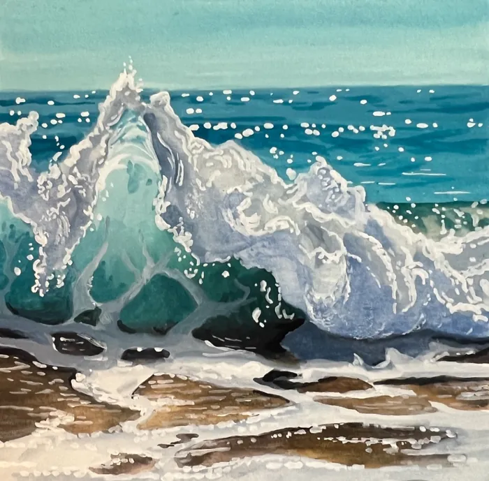 Ocean waves crashing on beach with white sea foam and blue water.