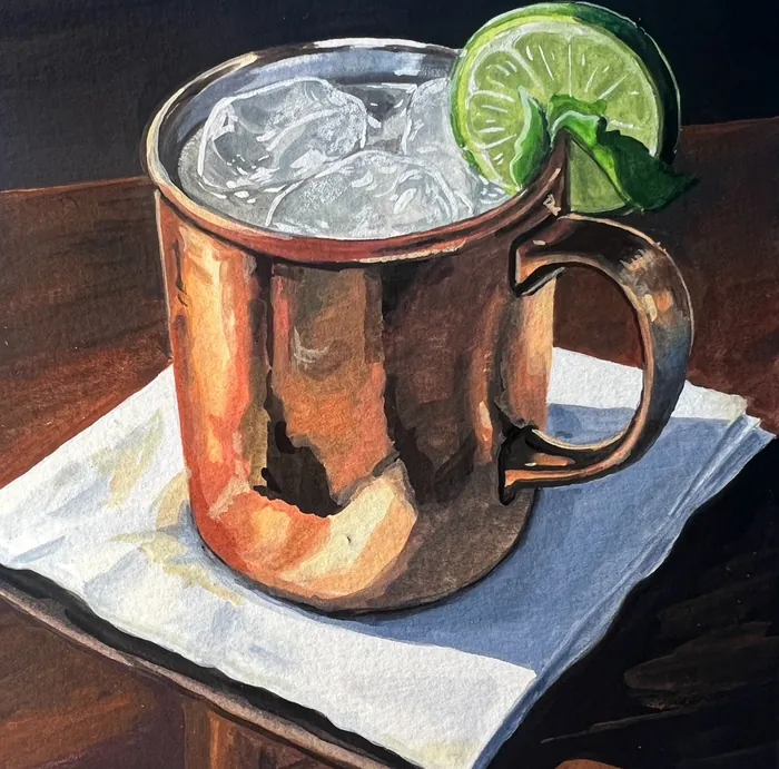 Copper mug with ice and lime wedge on white napkin