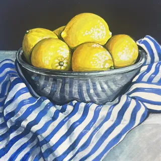 Bowl filled with lemons on blue and white striped fabric