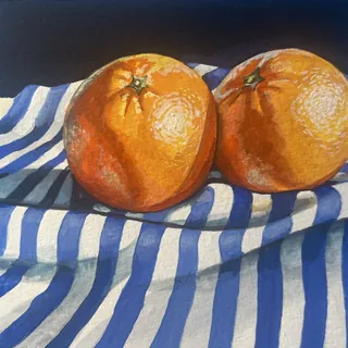 Two oranges on blue and white striped fabric with shadows