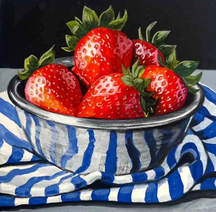 Bowl of fresh red strawberries on blue and white striped cloth