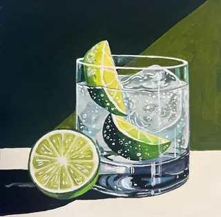 Glass of sparkling water with lime and ice cubes
