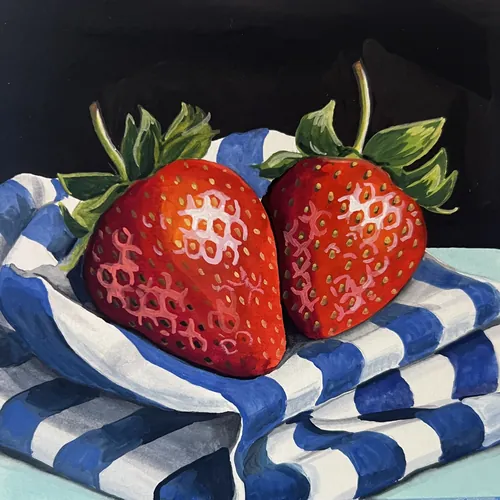 Two ripe strawberries on blue and white striped fabric