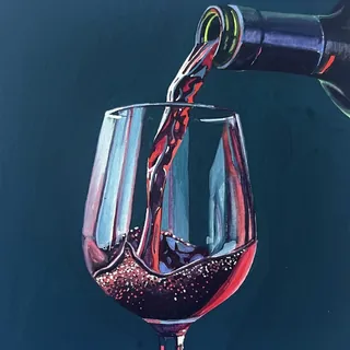 Glass of red wine being poured from bottle