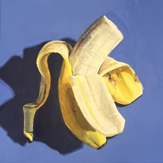 Partially peeled banana casting a shadow on blue background