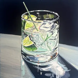 Cocktail glass with ice and lime on reflective table