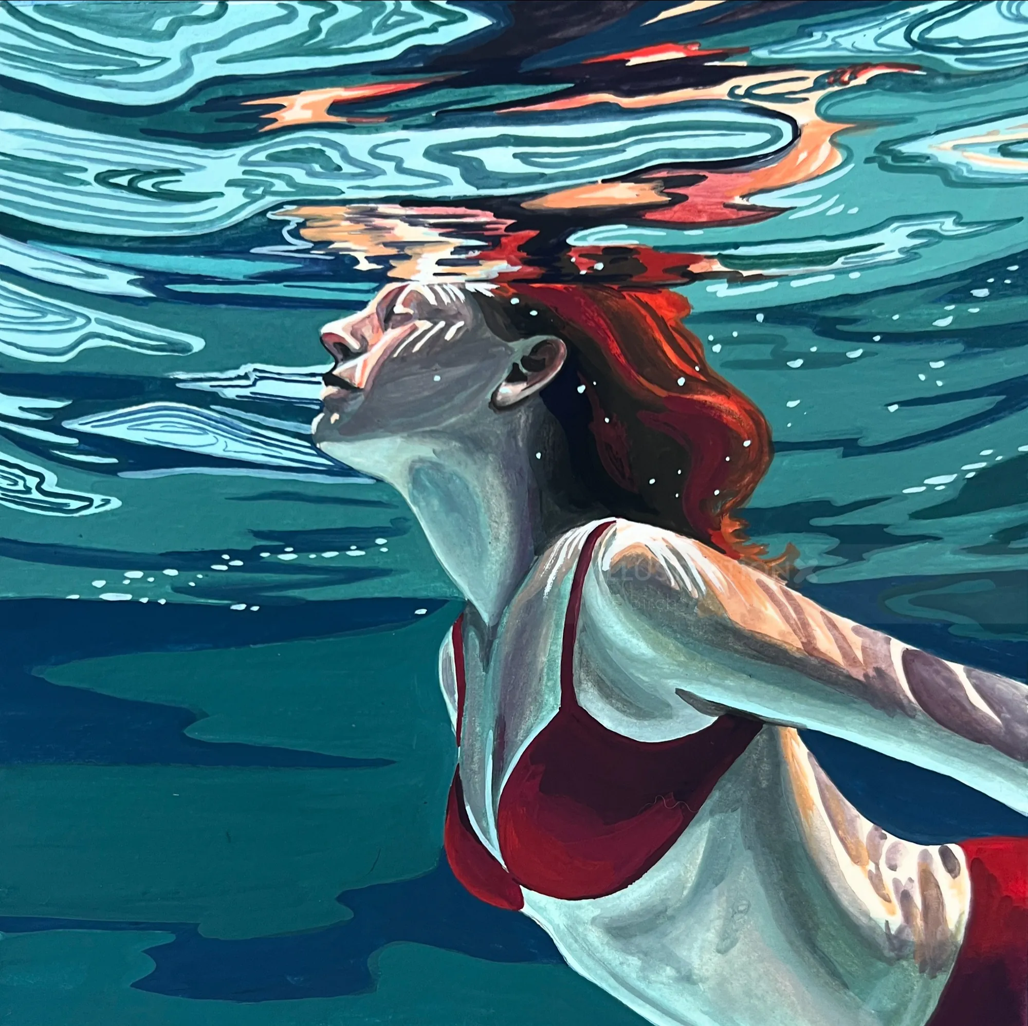 Woman with red hair swimming underwater in red swimsuit