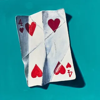 Folded four of hearts playing card casting shadow