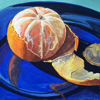 Peeled orange on a blue plate with orange peels